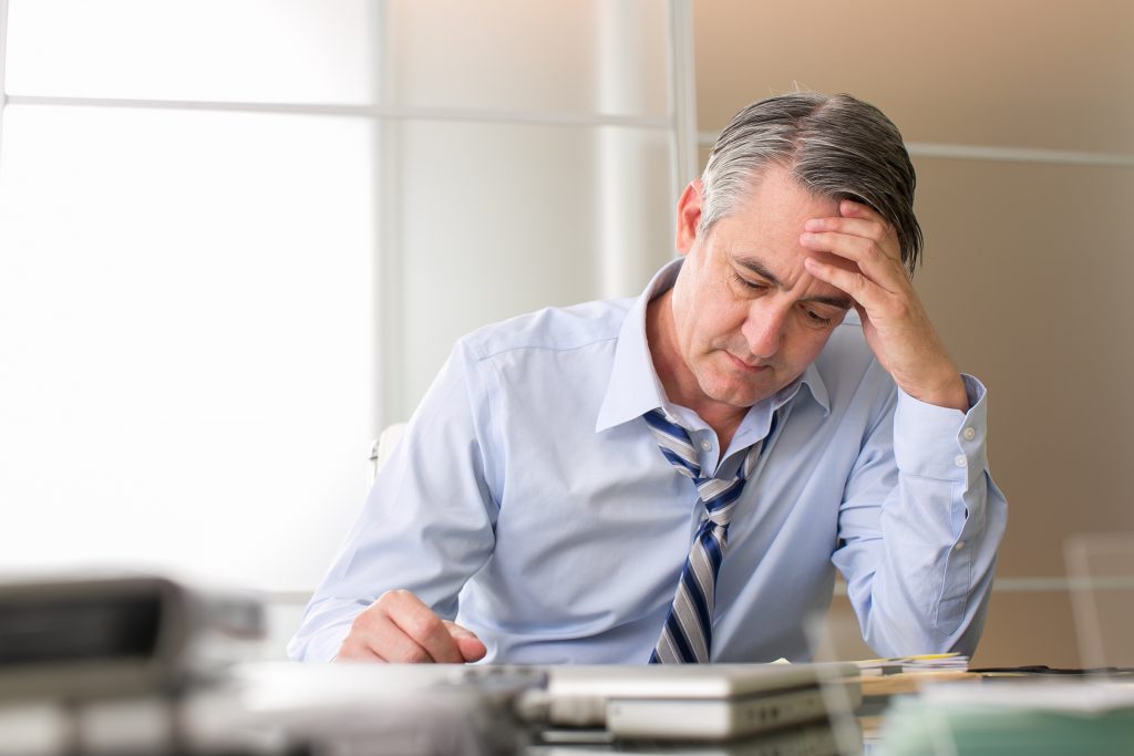 Man in blue shirt looking stressed