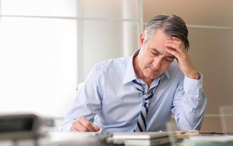 Man in blue shirt looking stressed