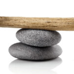 Rocks balancing upon a stick of wood upon stacked rocks