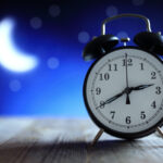 Alarm clock with blurred moon in background