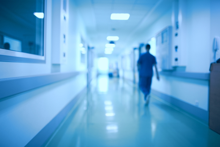 Blurred out hospital image with man in scrubs walking