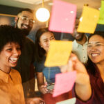 Group of coworkers smiling at post-it notes