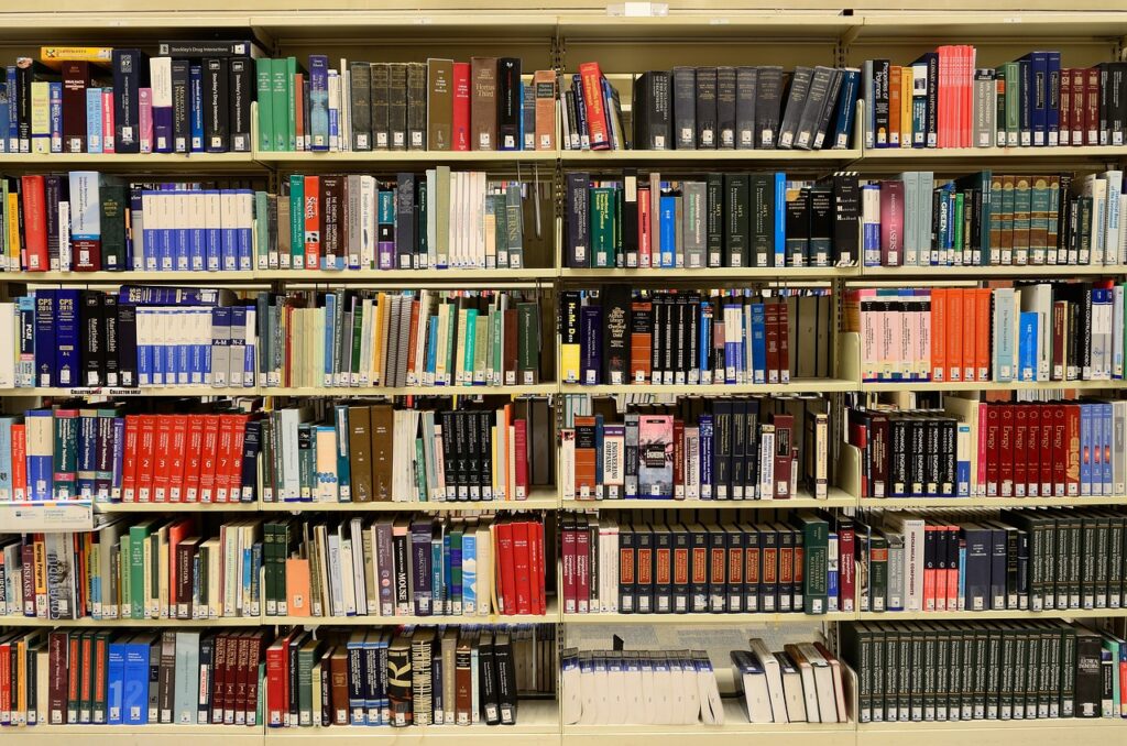 Image depicts wall of different coloured academic books